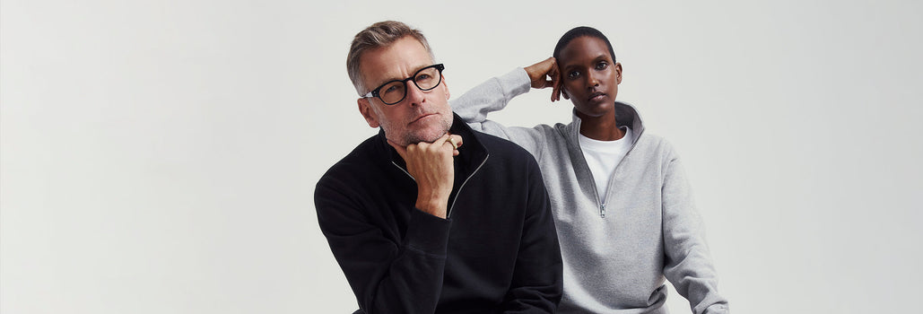 A man and a woman both wearing 1/4 zip sweaters