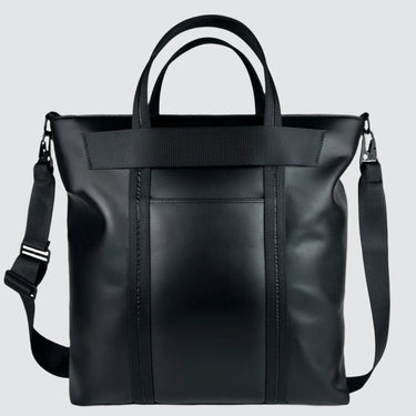 Back view of a medium-sized tote bag in black leather, with an exterior pocket and trolley sleeve