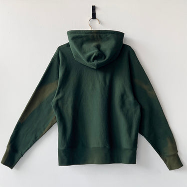 Green hoodie on a hanger against a white background