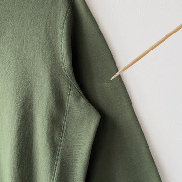 Green fabric with a small stain on a white background