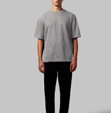 A black crew neck t-shirt with short sleeves on a model, against a plain background.