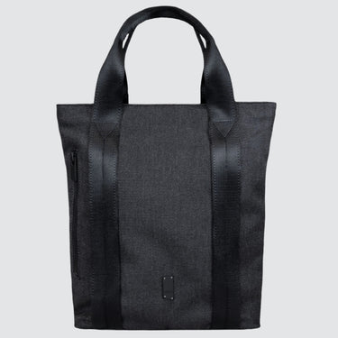 Tote bag made with grey twill material. There is a vertical black zipper on the left side, and the black seatbelt straps continue all the way down the front of the bag