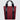 Tote bag made with red twill material. There is a vertical black zipper on the left side, and the black seatbelt straps continue all the way down the front of the bag