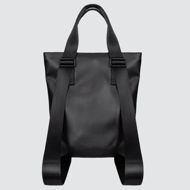 Back view of a totepack made with black vegan leather. The convertible strap is extended to show the backpack option
