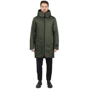 Male model stands facing camera wearing a evergreen parka on a white background