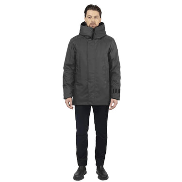 male model stands facing us, wearing a graphite utilitarian style waist length jacket on a white background.