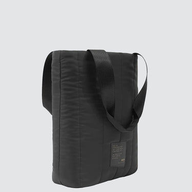 side profile of a black puff tote bag in quilted deadstock material, against a plain background