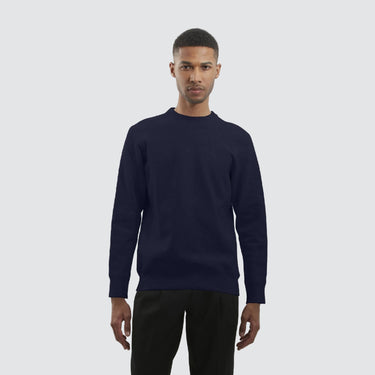Male model wearing a black crewneck against a white background