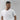 Man wearing a plain white t-shirt against a gray background