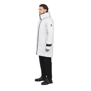 A man wearing a long white hooded parka with black trim and black pants, shown in profile against a light gray studio background.