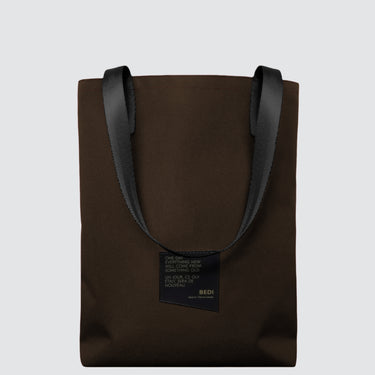 Brown tote bag with black handles on a light gray background