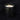 Candle in a black container labeled 'Feu de Bois' on a dark background