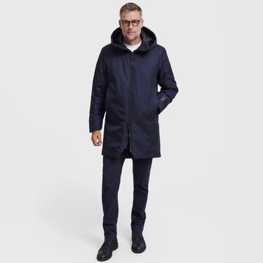 Man wearing a navy blue winter coat on a white background