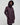 Woman wearing a long dark purple coat with a hood on a light grey background