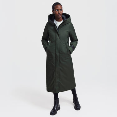 Woman wearing a long green coat on a white background
