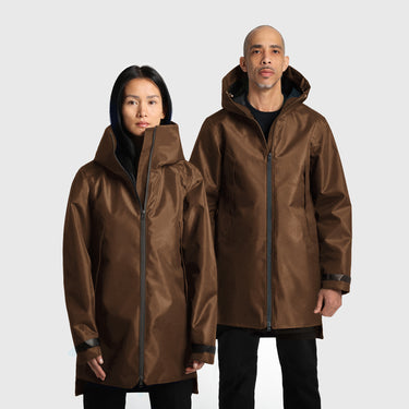 A male and a female model wearing brown raincoats on a white background