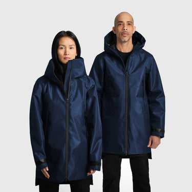 A male and a female model wearing navy blue raincoats on a white background