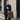 Woman holding a brown tote bag with items, walking on a city street.