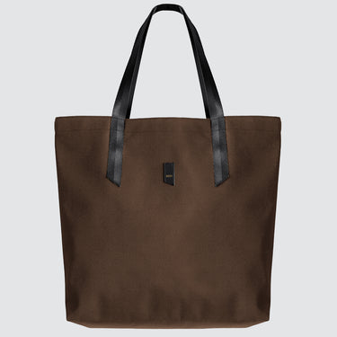 A brown nylon tote bag with black medium-length straps and a black patch with gold logo text