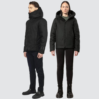 male and female model, both wearing black winter coats in a bomber jacket style