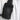 a close up of a black leather bag against a white shirt