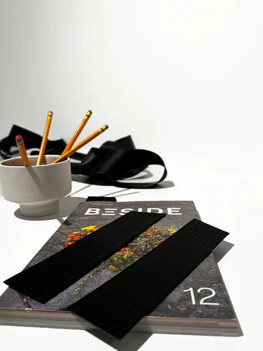 interesting bookmarks made of recycled seatbelts is showcased on top of a beside magazine