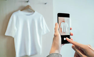 someone taking a product picture of a white shirt.