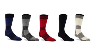 Merino wool socks in (navy, evergreen, red, black and natural colors) appear on a lateral row against a white background