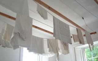 White shirts drying on a dryer line inside a white apartement
