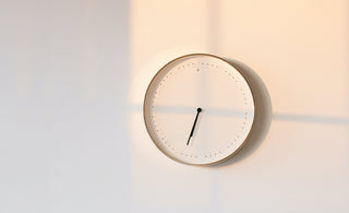 minimalist picture of a white clock on a white wall