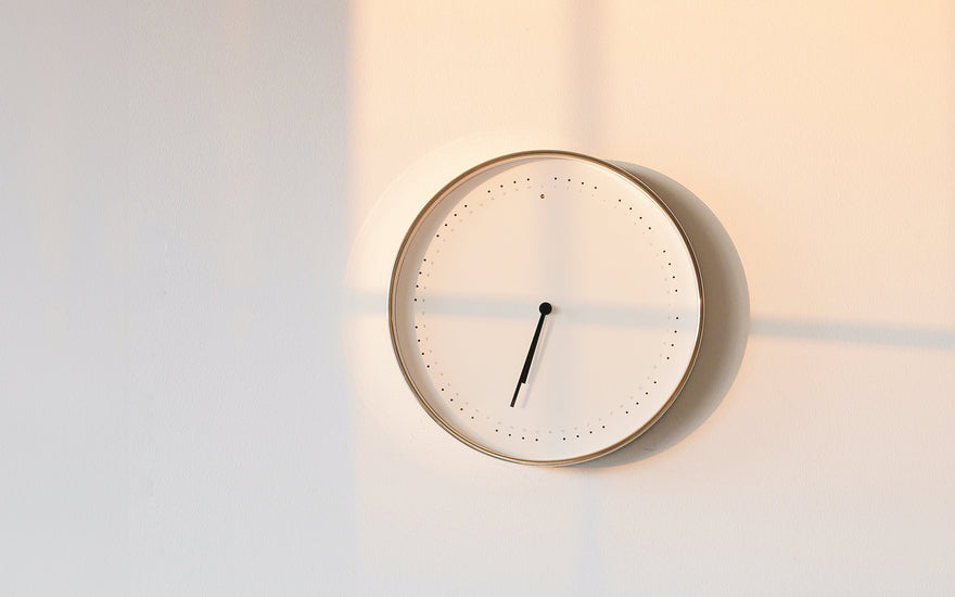 minimalist picture of a white clock on a white wall