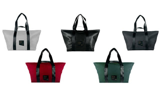 Five Shoalts bags on a white background- one each of red, green, white, black, and black vegan leather