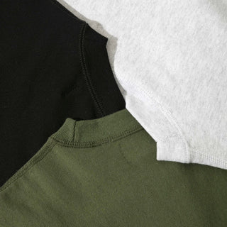 Three sweaters (green, black and grey) lay flat with a close up of the collars