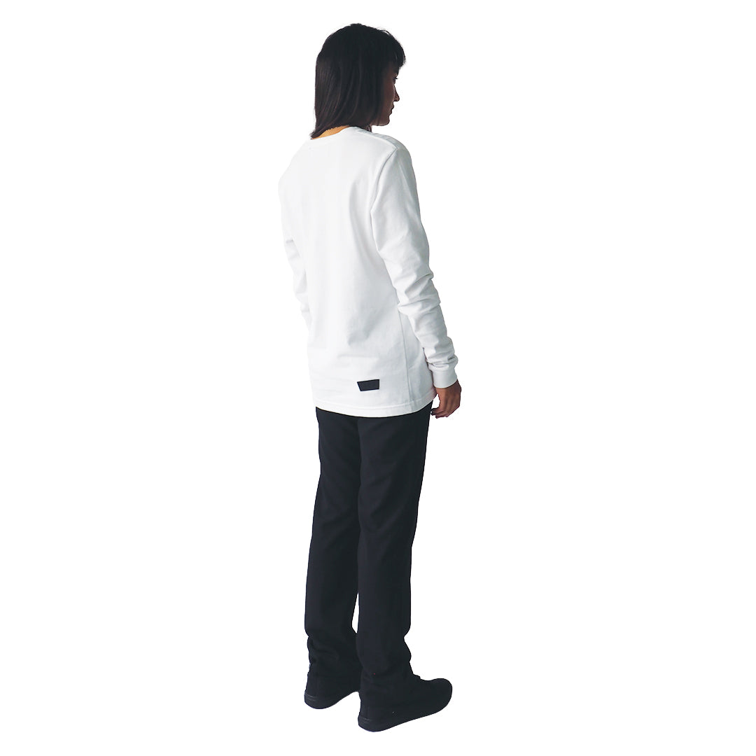 a female model stands, a close up of her side shown to the camera wearing a white light long sleeve tee on a white background