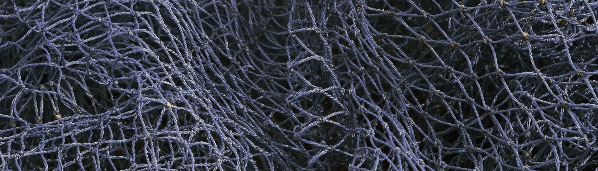 Close up of dark blue fishing net in a pile