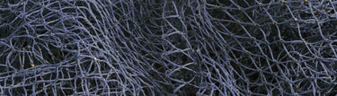 Close up of dark blue fishing net in a pile
