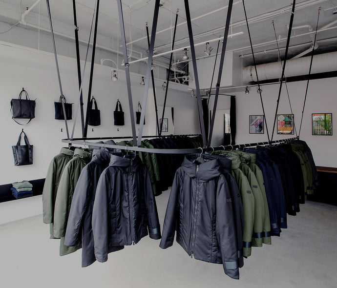 Interior of the Bedi store, showing the coats on a floating rack suspended by seatbelts