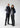 Two people wearing matching gray and black outfits on a white background