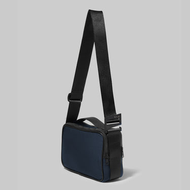 Navy crossbody bag on a grey background
