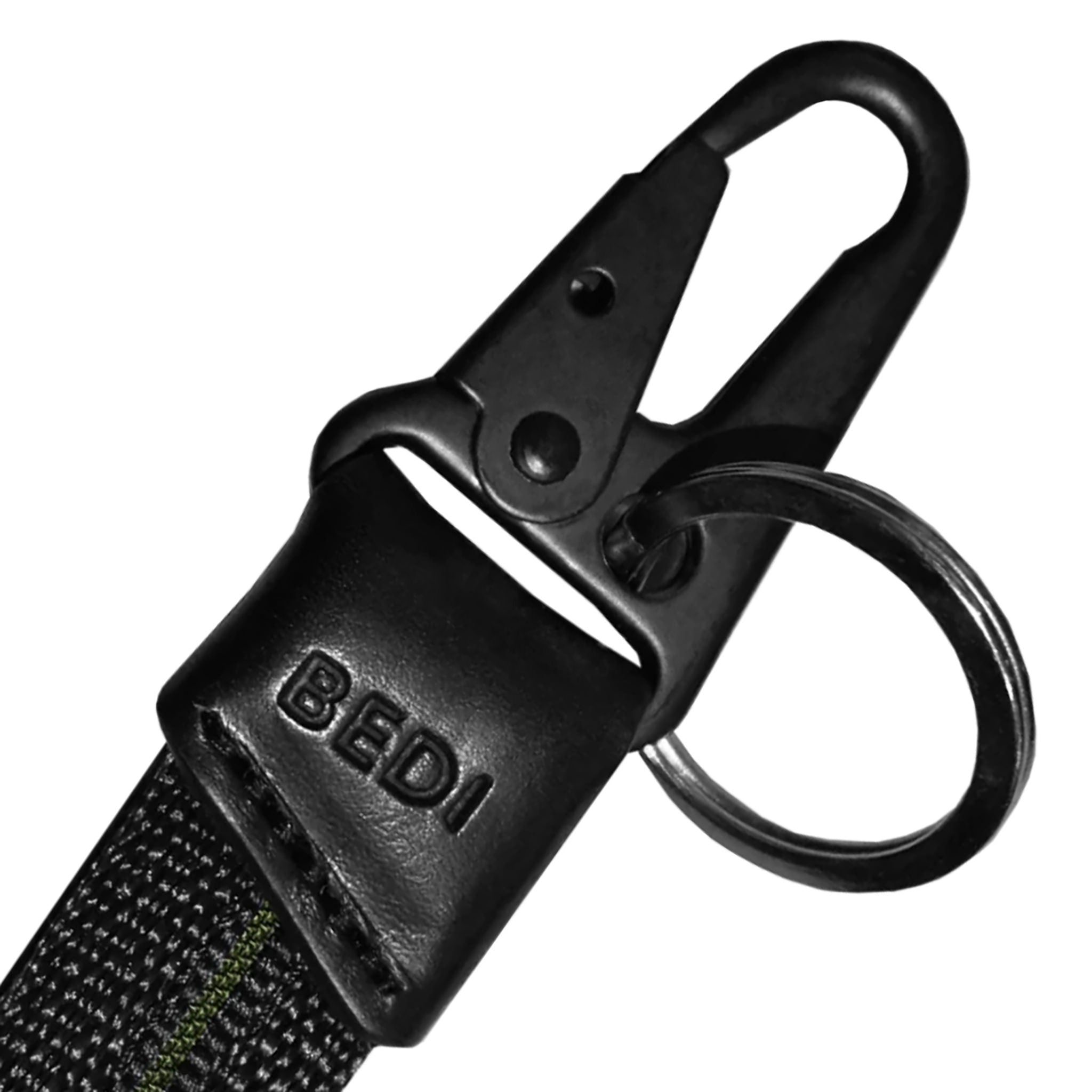 Close up on hardware of black keychain made from seatbelt material, with thin line of inset green down the middle