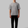 A black crew neck t-shirt with short sleeves on a model, against a plain background.