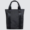 Tote bag made with grey twill material. There is a vertical black zipper on the left side, and the black seatbelt straps continue all the way down the front of the bag