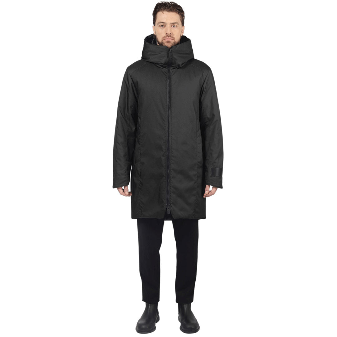 Male model stands facing camera wearing a black parka on a white background