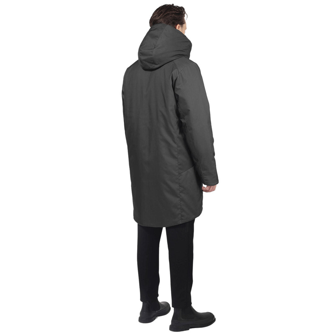 Male model stands back facing camera wearing a grey parka on a white background
