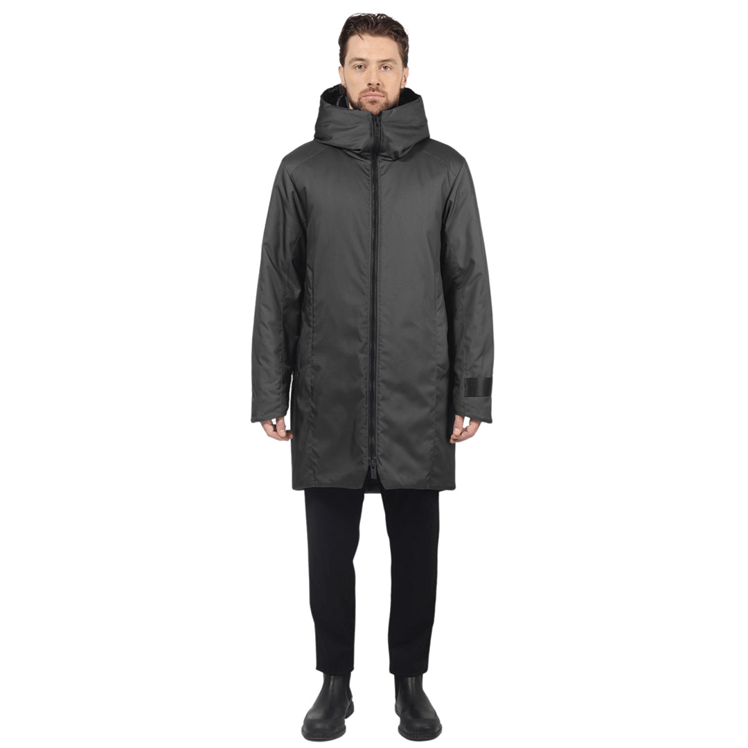 Male model stands facing camera wearing a graphite parka on a white background