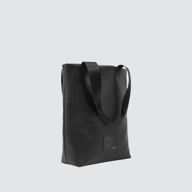 side profile of utilitarian style medium sized tote in black vegan leather (Desserto)
