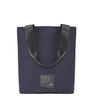 A minimalist navy tote bag with an upcyled seatbelt strap. A black logo patch is in on the lower middle part of the bag