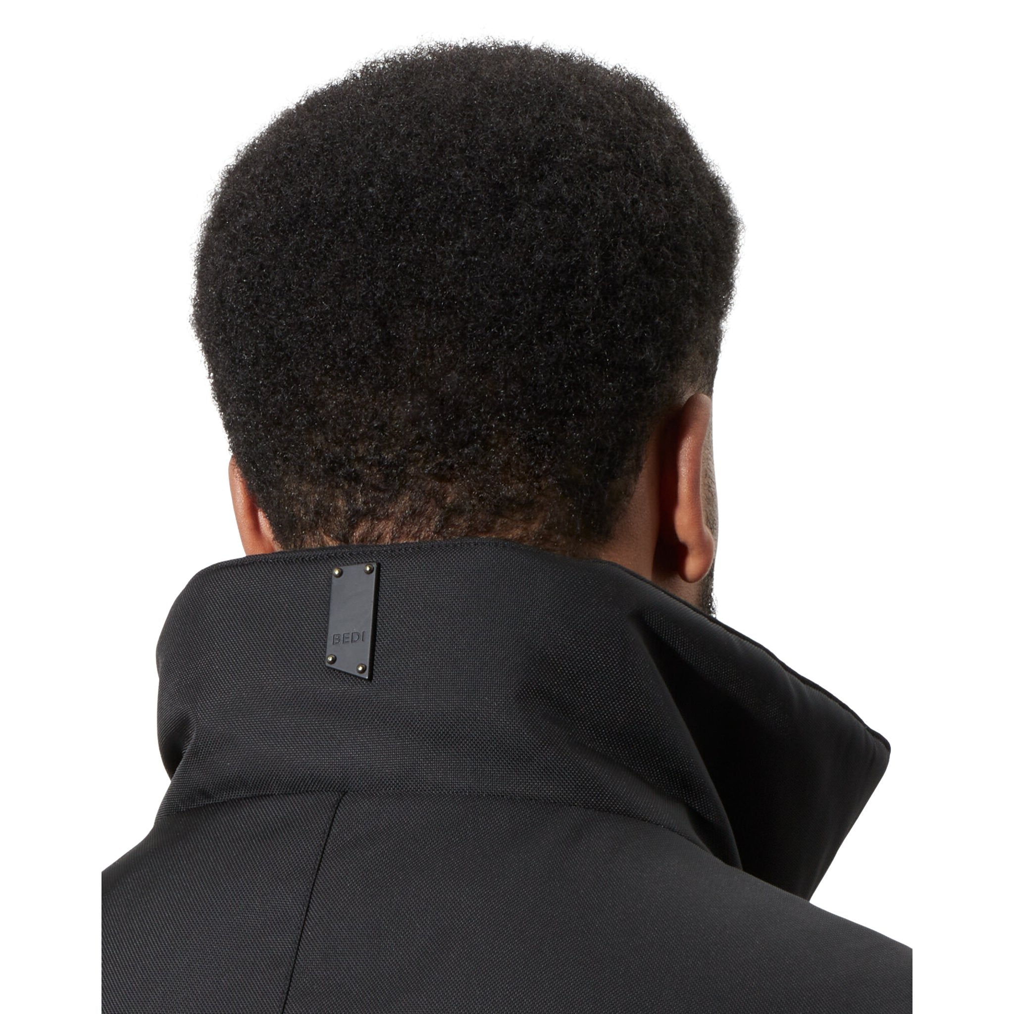 Close up view of the high neck of the black Montcalm vest, on a man with short dark hair