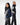 A man and a woman walk past each other both wearing vests