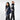 A man and a woman walk past each other both wearing vests